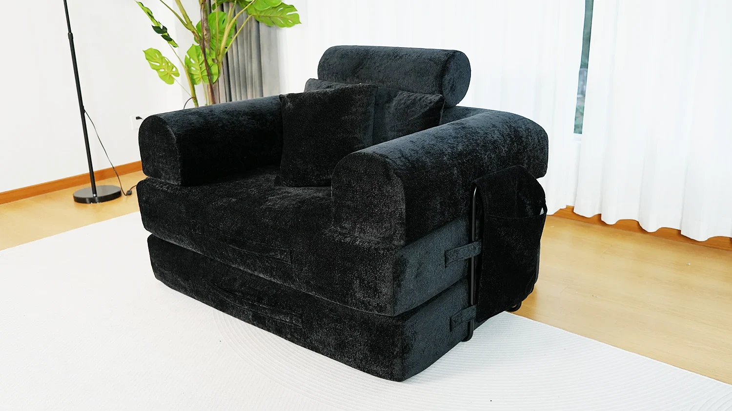 Black plush multifunctional folding sofa chair with side storage pocket and armrests for small apartment.